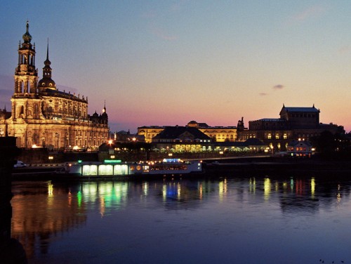 Nachtaufnahme von Dresden. Über die Elbe kann man den Theaterkahn und eine ausgeleuchtete Kirche sehen.