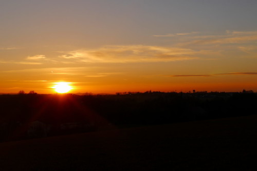 Das Bild zeigt einen Sonnenuntergang, die Sonne berührt gerade die Erde