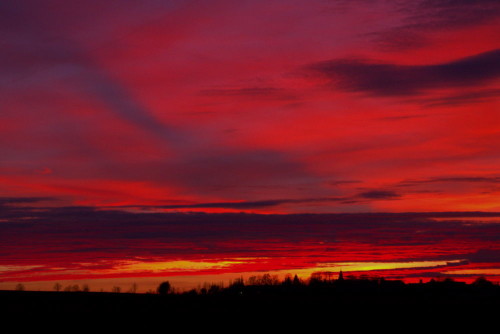 Das Bild zeigt den Himmel kurz nach Sonnenuntergang, durch die Rot- und Orangetöne scheint er zu brennen...