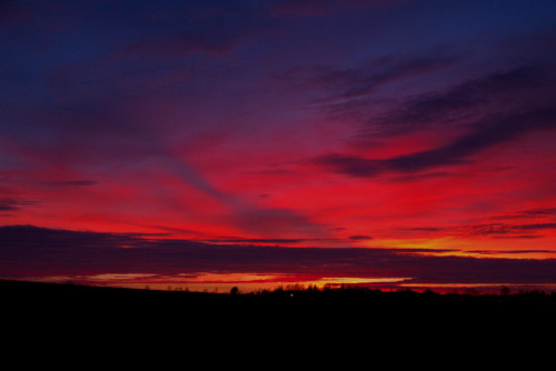 Das Bild zeigt den Himmel kurz nach Sonnenuntergang, durch die Rot- und Orangetöne scheint er zu brennen...