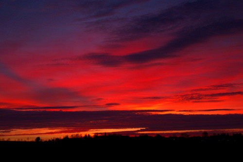 Das Bild zeigt den Himmel kurz nach Sonnenuntergang, die Wolken und der Himmel scheinen rot zu brennen...