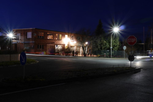 Das Bild zeigt die THW-Unterkunft in Schöningen bei Nacht. Ein flaher Gewerbebau. Im Vordergrund sind Straßen und Straßenschilder