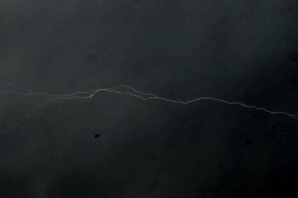 Das Foto zeigt einen Blitz, der in der Bildmitte fast waagerecht durch das Bild geht und sich auf der linken Seite aufsplittert.