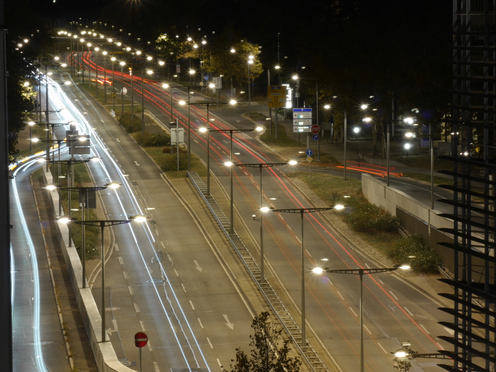 Das Foto zeigt die Langzeit-Aufnahme einer mehrspurigen Straße in Dresden. Aufgrund der langen Belichtungszeit sind die Lichter der Fahrzeuge nur Streifen.