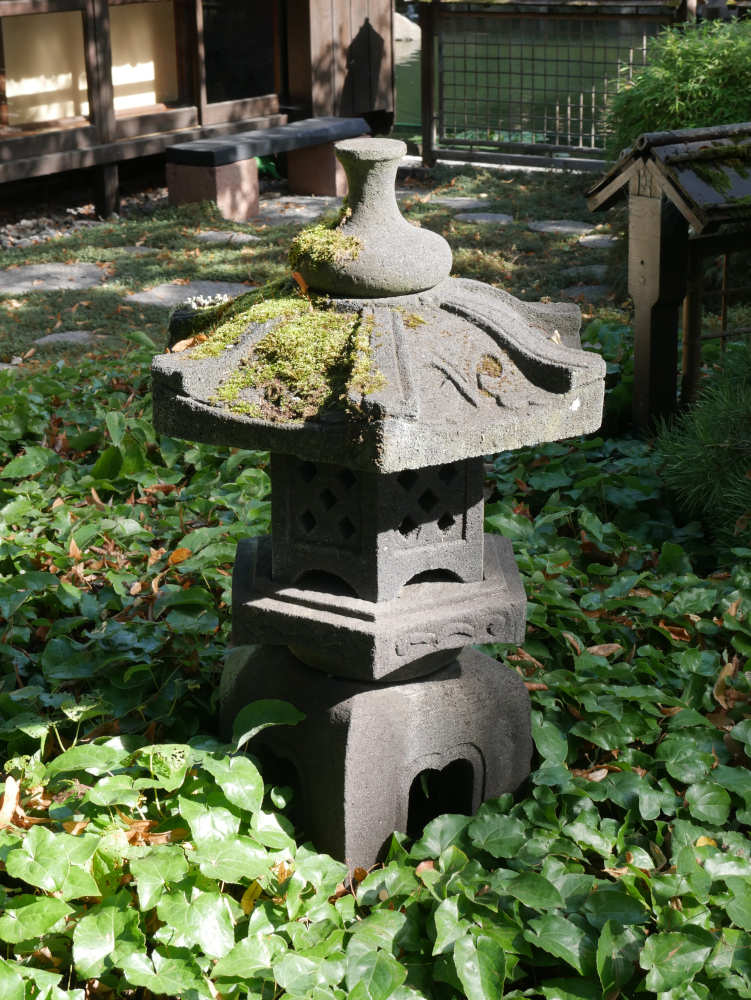 Das Foto zeigt eine japanische Stein-Skulptur in einem Garten.