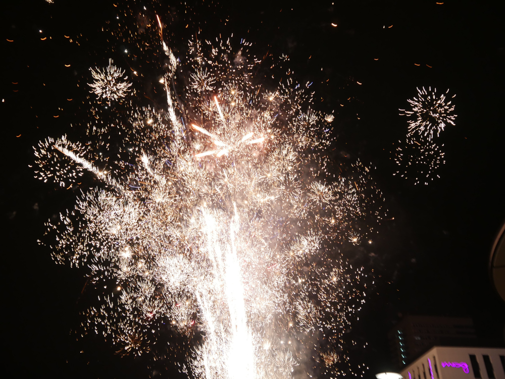 Das Foto zeigt sehr viele helle, weiße Feuerwerksexplosionen am Nachthimmel.